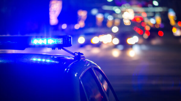 Polizeiauto mit Nachtlichtern im Hintergrund.